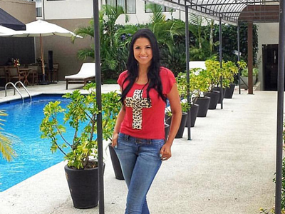 10-	Picture of a guest wearing a red shirt and blue jeans, standing beside the pool at the Costa Rica Medical Center Inn, San Jose, Costa Rica.