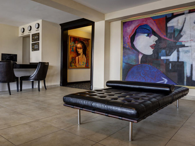 1-	Picture of the lobby of the Costa Rica Medical Center Inn, San Jose, Costa Rica.  The picture shows a spacious interior and large picture on the wall.